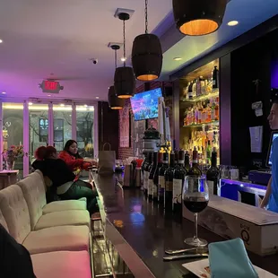 a bar with people sitting at the bar