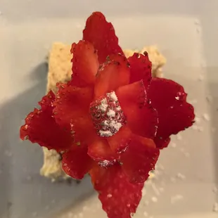 a strawberry flower on a piece of cake