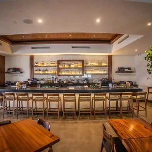 a view of a bar with wooden tables and chairs