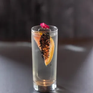 a shot of a drink with a slice of orange