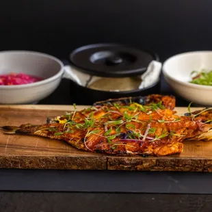 a whole fish on a wooden cutting board