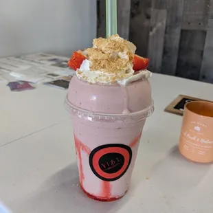 a strawberry milkshake with whipped cream and strawberries