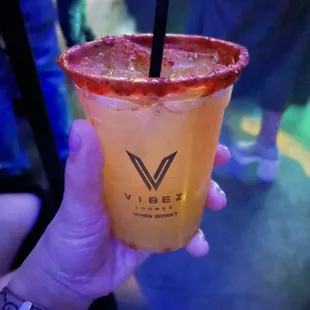 a hand holding a drink with a straw