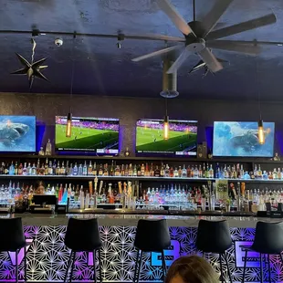 a bar with multiple televisions on the wall