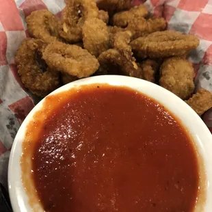a plate of fried chicken wings and a bowl of sauce