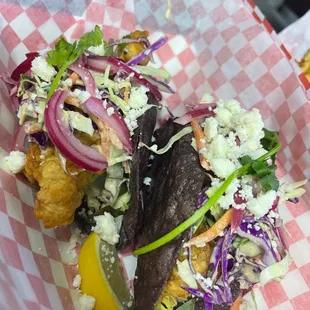 Fish tacos ~ beer battered fresh cod, escabeche, queso fresco, roasted Serrano crème fraîshe, savage sauce, cilantro and pickled red onions