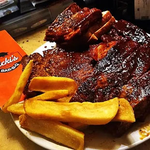 ows a plate of ribs and french fries