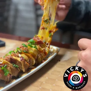 a person holding a piece of pizza