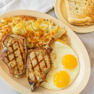 Introducing our Pork Loin Chops Breakfast Platter, a hearty morning indulgence that will tantalize your taste buds.