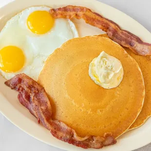 Indulge in our savory Pancake Breakfast including two buttermilk pancakes topped with whipped butter, two extra large eggs (any style) and y