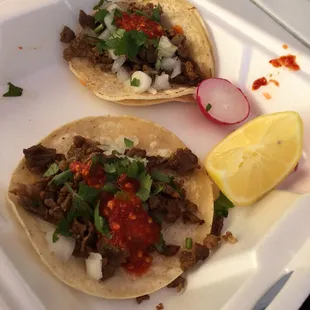 two tacos in a styrofoam container
