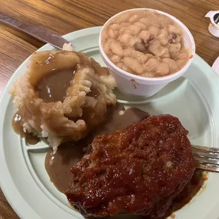 Home made meatloaf , mashed potatoes and baked beans.