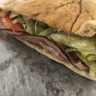 a sandwich with meat, lettuce, and tomato