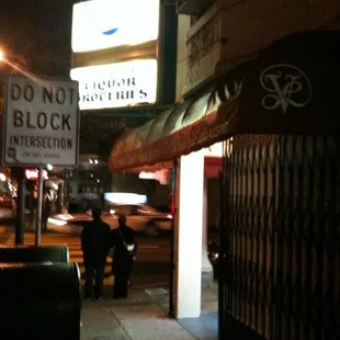 people walking down the sidewalk at night