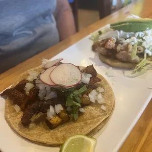 Pastor taco in near photo and chicken Sopes in rear