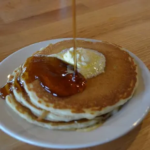 a stack of pancakes with butter and syrup