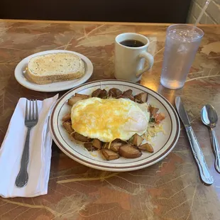 Veggie skillet red skin potatoes mushrooms onions green pepper eggs over easy with Monterey Jack cheese rye  toast  and coffee