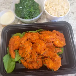 Buffalo shrimp with sautéed spinach and seafood salad.