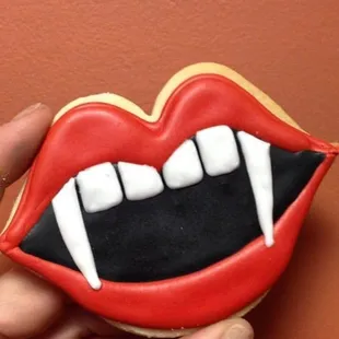 a hand holding a decorated cookie