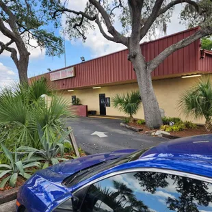 a blue car parked in front of the restaurant
