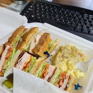 Club sandwich on rye toast. Side of potato salad and two pickle spears.