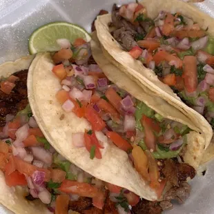 Carne Asada, Al Pastor, and Carnitas tacos, topped with Pico de Gallo &amp; cilantro.