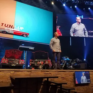 Pastor Steve on stage preaching about the security of tuning up the soul.