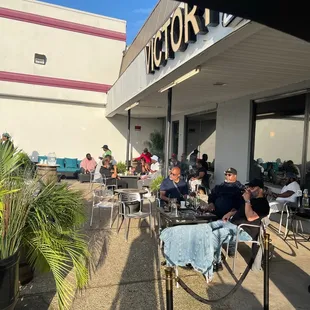 a group of people sitting outside a restaurant
