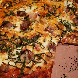 Thin crust with sausage, garlic, onions, and basil. (Notice the burnt particles?)