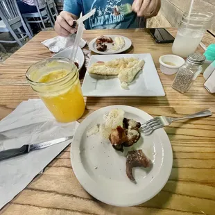 My maracuya (passion fruit) drink is blocking the side order chicharrón (pork cracklings). The big plate in the middle is yuca.