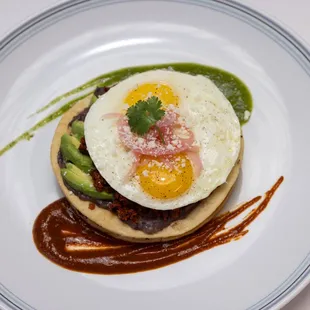 a plate of food with an egg and avocado