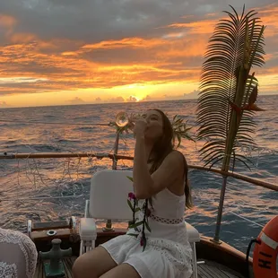 My friend enjoying some champagne while the sun sets behind her