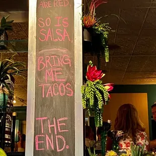a chalkboard with the words roses are red salsa brine tacos the end