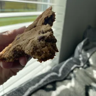 a hand holding a half eaten cookie