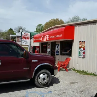 a red truck parked in front of a cafe