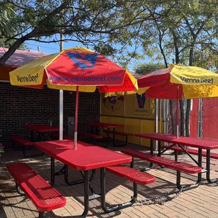 red picnic tables with yellow umbrellas