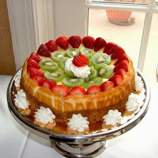 a strawberry kiwi cheesecake with whipped cream