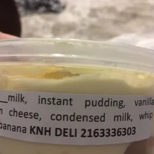 a hand holding a container of yogurt