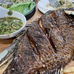 (insert applause) Well made fried tilapia on cute plank board