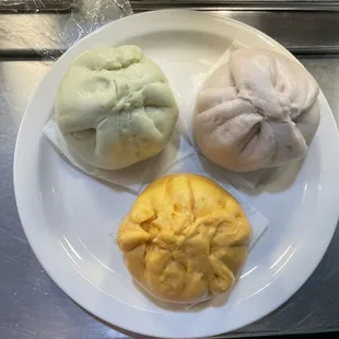 three steamed buns on a plate