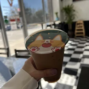 a hand holding a cup of yogurt