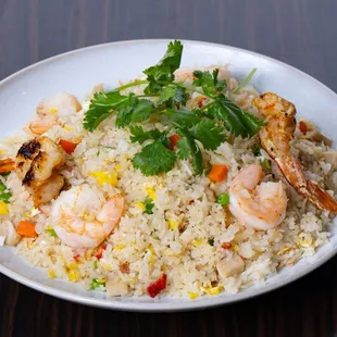 a plate of rice with shrimp and vegetables