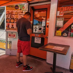 a man standing in front of a vending machine