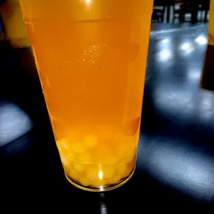 Passion fruit green tea with mango and lychee popping boba