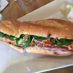 Banh Mi - Vietnamese ham, pork belly, pâté, cha lua sausage, quick pickled carrots, cilantro and jalapeño on a light baguette ($7).