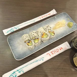 a plate of sushi and chopsticks