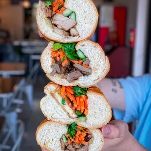 a person holding a sandwich
