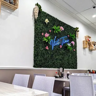 a dining area with white chairs and a green wall