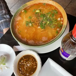 a bowl of soup and a bottle of beer