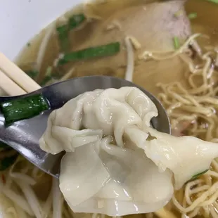 a bowl of soup with noodles and dumplings
